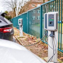 Foto von E-Autos, die an eine E-Ladesäule angeschlossen sind.