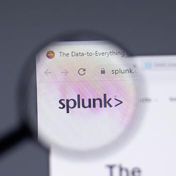 Das Bild zeigt eine digitale Lupe, die einen Bildschirm vergrößert, auf dem "Splunk, The Data to Everything" steht.